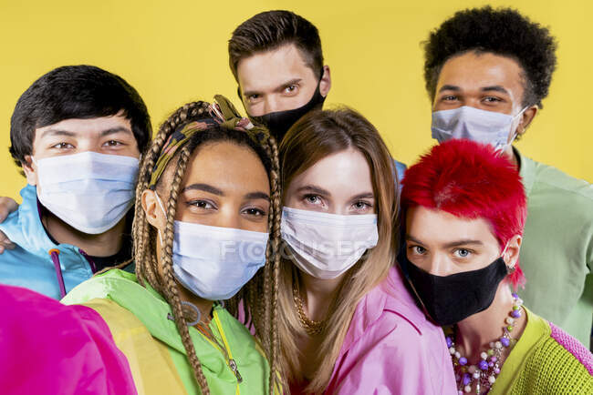 Друзья в защитной маске делают селфи через мобильный телефон — стоковое фото