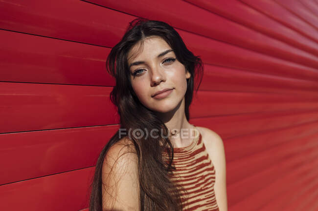 Ragazza adolescente in piedi davanti al muro rosso — Foto stock