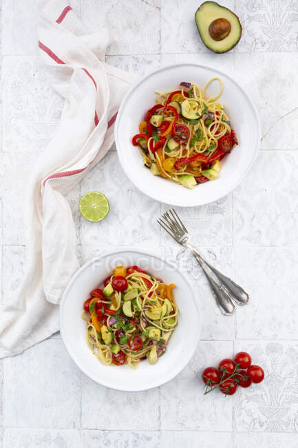 Spaghetti with grilled vegetables, paprika, zucchini, avocado, tomato and coriander — Stock Photo