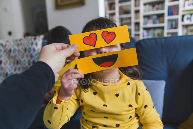Hombre y chica jugando con emoticonos en casa - foto de stock