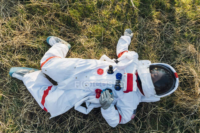 Female astronaut lying on land in forest - foto de stock