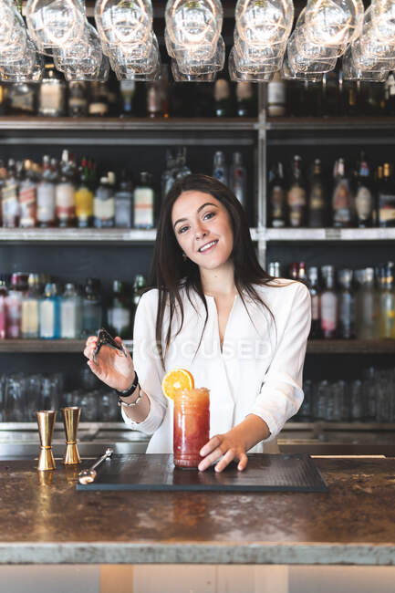Посмішка красива самиця бармен обслуговує тонг за барною стійкою — стокове фото
