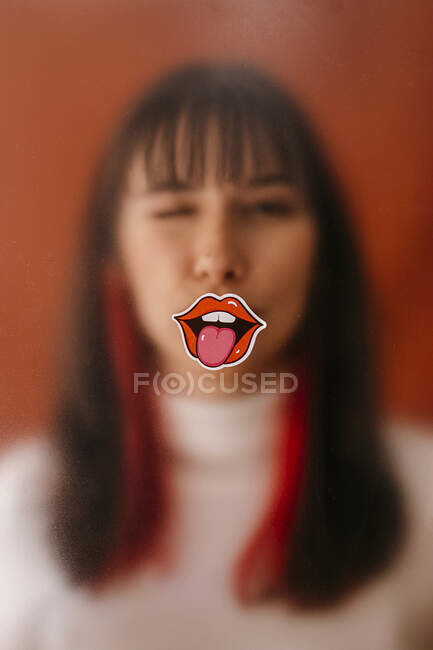 Adesivo labbra su foglio di plastica davanti alla donna — Foto stock