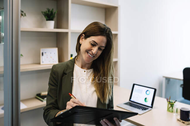 Smiling female entrepreneur making business strategy while working at office — Stock Photo