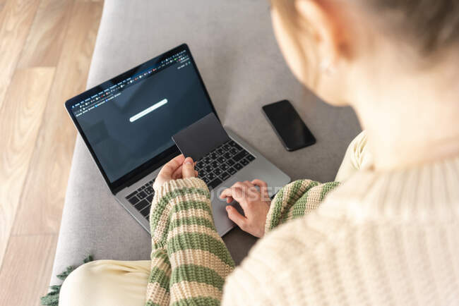Woman with credit card paying online on laptop at home — Stock Photo