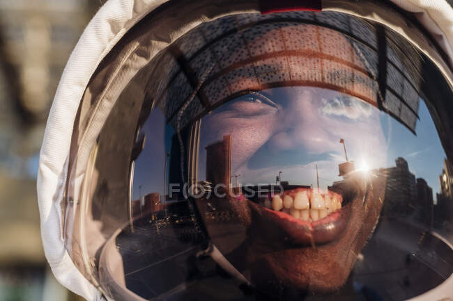 Smiling man wearing space helmet looking away during sunny day — Stock Photo