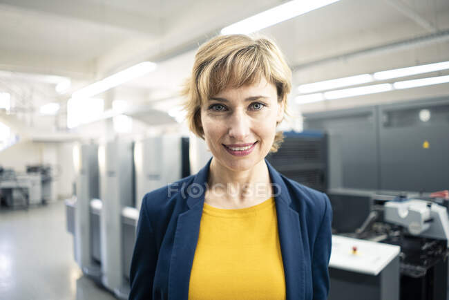 Donna d'affari matura sorridente nell'industria della stampa — Foto stock