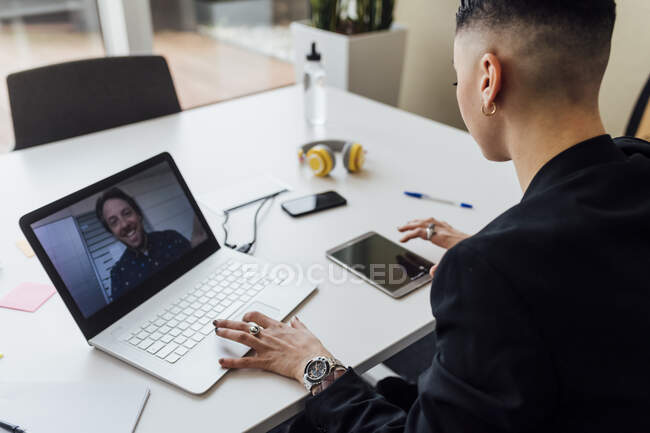Unternehmerin nutzt digitales Tablet bei Videotelefonie über Laptop im Büro — Stockfoto