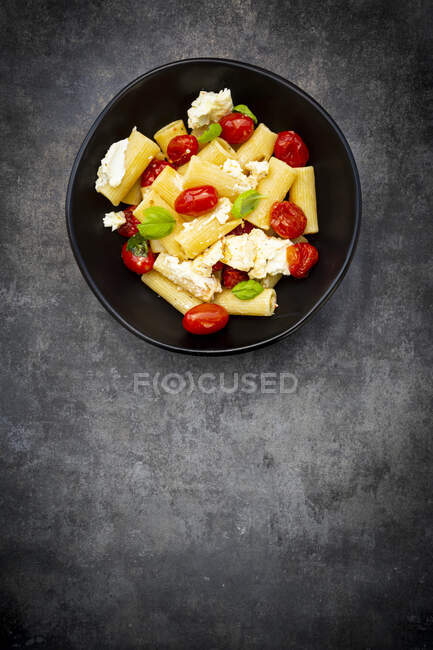Rigatoni pasta with baked tomatoes, feta and basil — Stock Photo