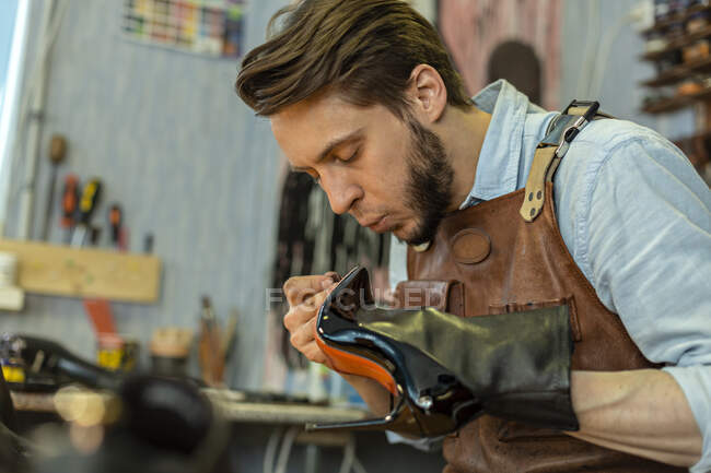 Mâle cordonnier collage chaussure à l'atelier — Photo de stock