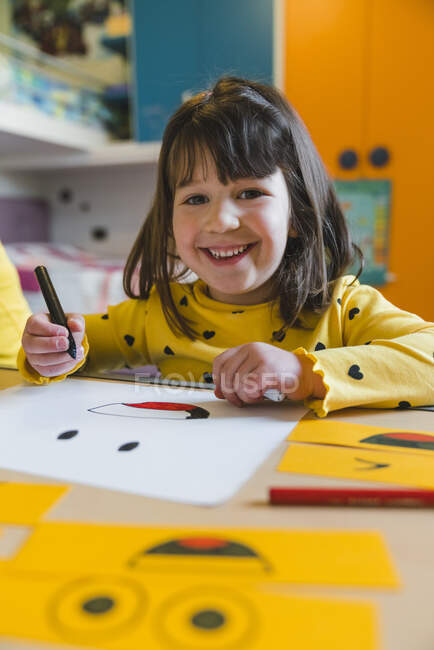 Ragazza con frangia che tiene il pennarello mentre gioca a casa — Foto stock