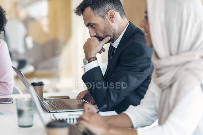 Berufstätige Männer und Frauen nutzen Laptops im Büro — Stockfoto