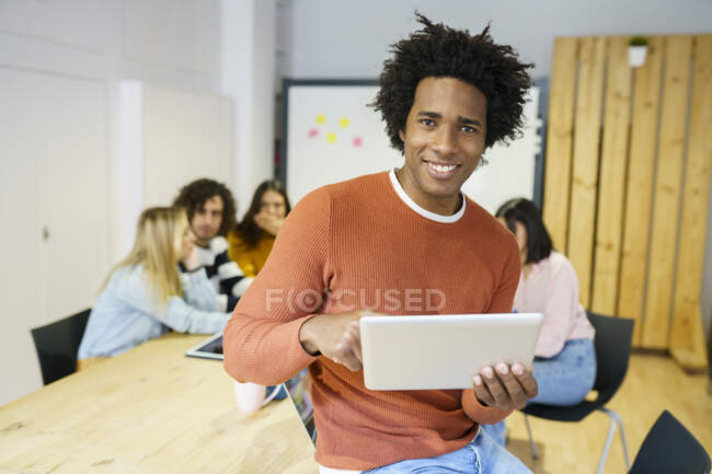 Felice maschio professionale utilizzando tablet digitale alla scrivania dell'ufficio — Foto stock