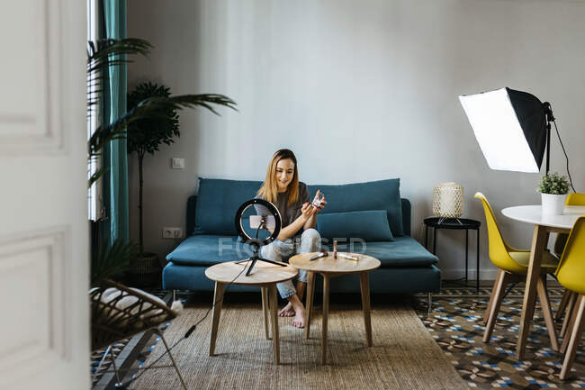 Influenceur féminin filmant tutoriel par téléphone portable à la maison — Photo de stock
