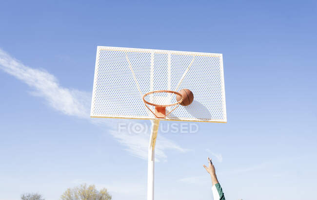 Jeune homme jouant au basket sur le terrain — Photo de stock