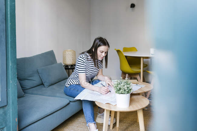 Женщина пишет на газете в квартире — стоковое фото