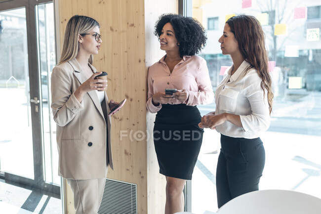 Professioniste che discutono durante la pausa caffè in ufficio — Foto stock