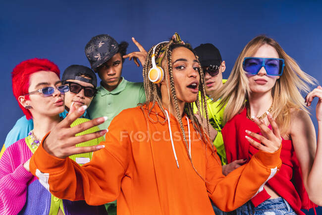 Cool friends dancing together in front of blue background — Stock Photo