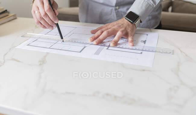Hombre haciendo plan de construcción en el escritorio - foto de stock