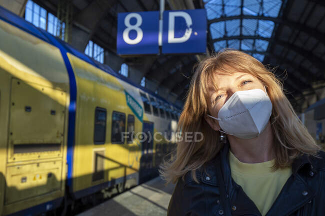 Femme mûre portant un masque protecteur à la gare pendant la pandémie — Photo de stock
