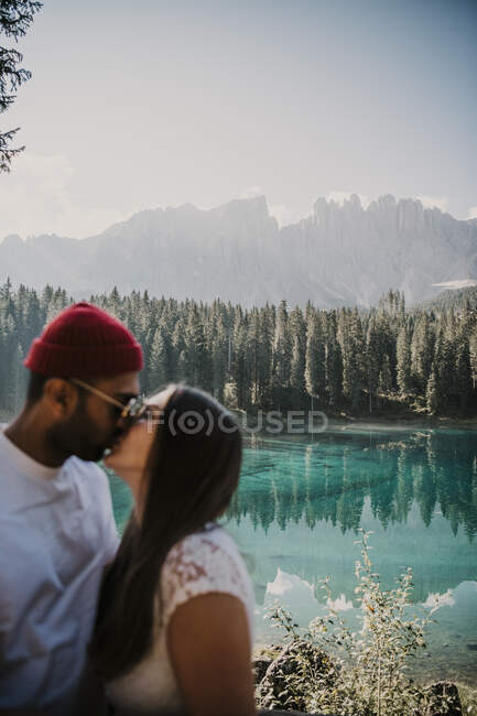Giovane coppia che si bacia al lago di Carezza in Alto Adige — Foto stock