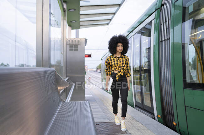 Giovane donna con computer portatile a piedi sulla piattaforma alla stazione ferroviaria — Foto stock