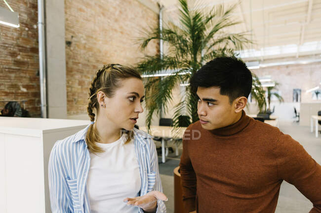Male and female business professionals discussing at coworking office — Stock Photo
