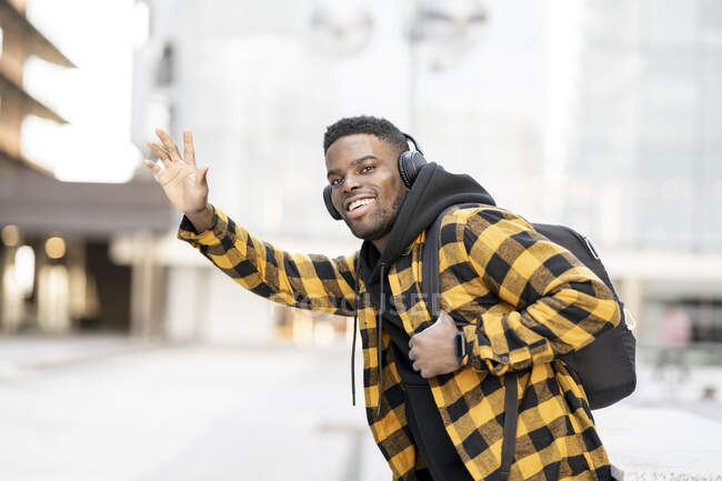 Smiling young African-American man hailing ride — Stock Photo