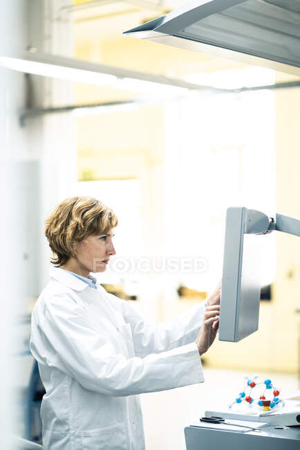 Mature scientist operating manufacturing machine in laboratory — Stock Photo