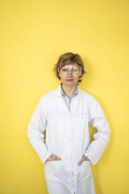 Competenza femminile in piedi davanti al muro con le mani in tasca — Foto stock