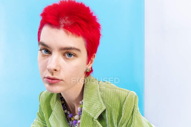 Привлекательная рыжая женщина, смотрящая на синий и белый фон — стоковое фото