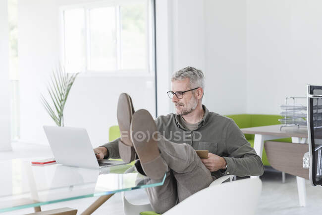 Бізнесмен працює на ноутбуці в офісі. — стокове фото