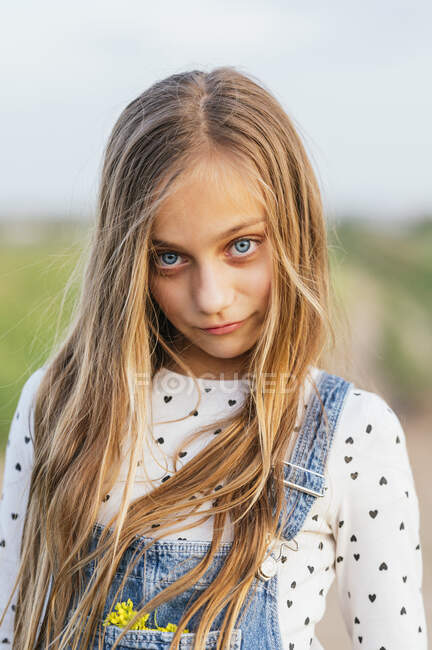 Блондинка с голубыми глазами стоит на поле — стоковое фото