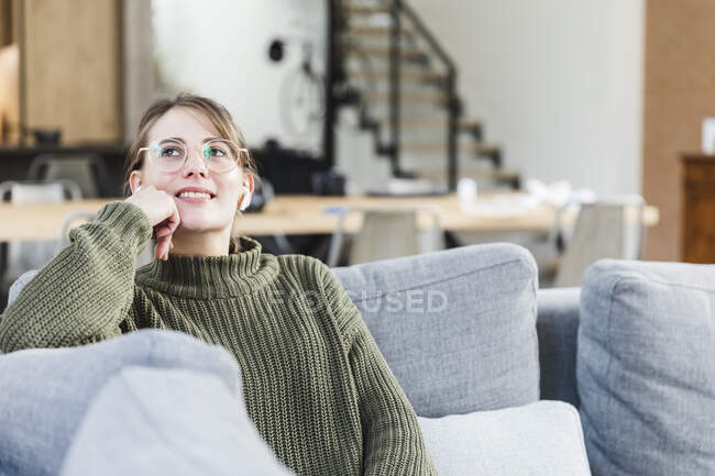 Mulher pensativo sentado no sofá na sala de estar em casa — Fotografia de Stock