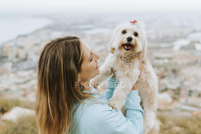 Mulher adulta média olhando enquanto segurando animal de estimação — Fotografia de Stock