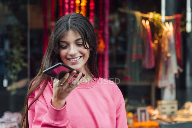 Sorrindo adolescente olhando para o telefone celular — Fotografia de Stock
