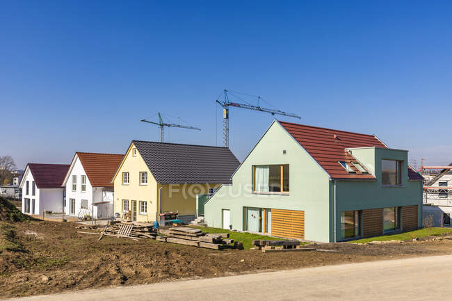 Німеччина, Баден-Вуртемберг, Людвігсбург, Чисте небо над новим сучасним районом розвитку з промисловими кранами на задньому плані. — стокове фото