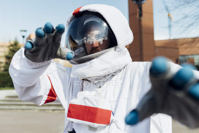 Young male astronaut in space suit gesturing outdoors — Stock Photo