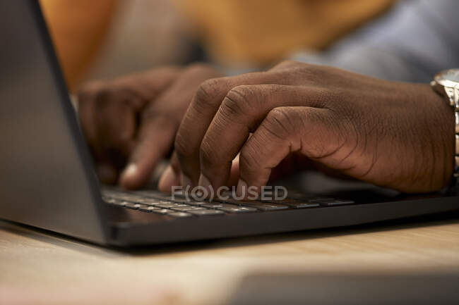 Hombre escribiendo en el ordenador portátil en la oficina - foto de stock