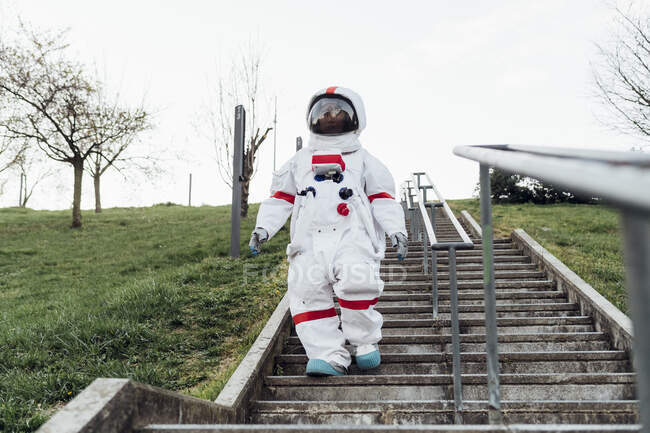 Astronauta donna che scende su scale nel parco — Foto stock