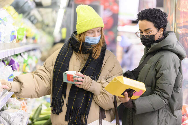 Female friends wearing warm clothing in supermarket — Stock Photo