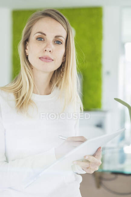 Empresária loira com bloco de notas no escritório — Fotografia de Stock