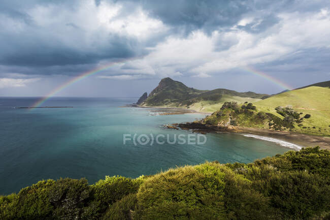 Arco-íris contra nuvens de tempestade que se reúnem na costa da Península de Coromandel — Fotografia de Stock