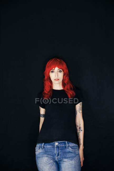 Female hipster woman standing against black background — Stock Photo