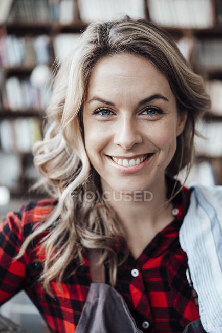 Camarera rubia sonriendo en el café - foto de stock