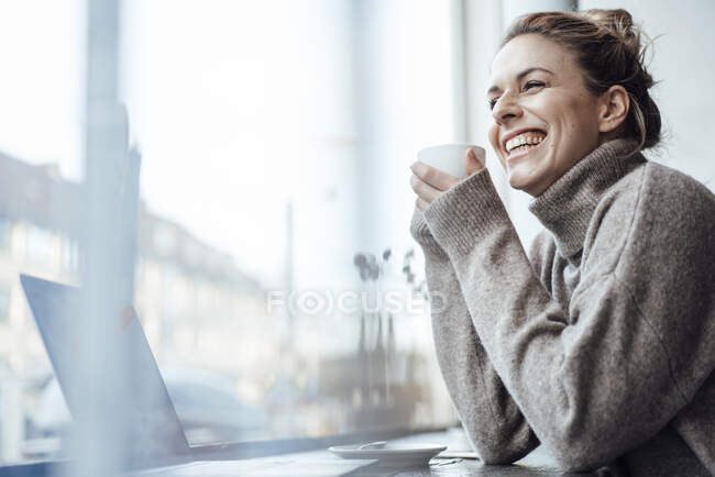 Fröhliche erwachsene Frau mit Kaffeetasse im Café — Stockfoto