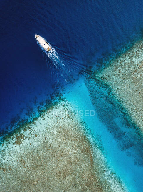 Aerial view of boat sailing near coast of Thulusdhoo island, Maldives — Stock Photo