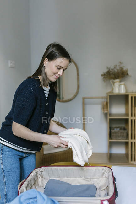 Женщина распаковывает чемодан в квартире — стоковое фото