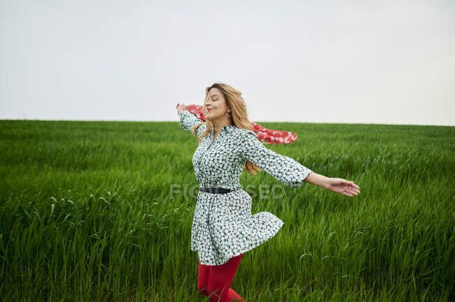 Безтурботний жінка насолоджується шарфом на лузі — стокове фото