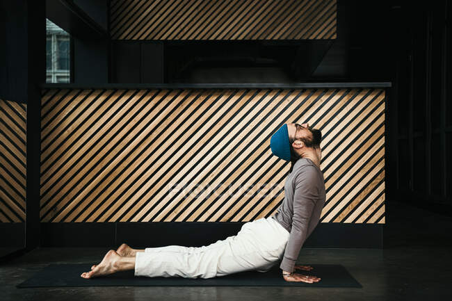 Männlicher Fitnesstrainer übt Kobra-Pose im Fitnessraum — Stockfoto